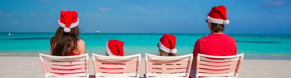 Felice famiglia di quattro persone in cappelli di Natale durante le vacanze tropicali — Foto Stock