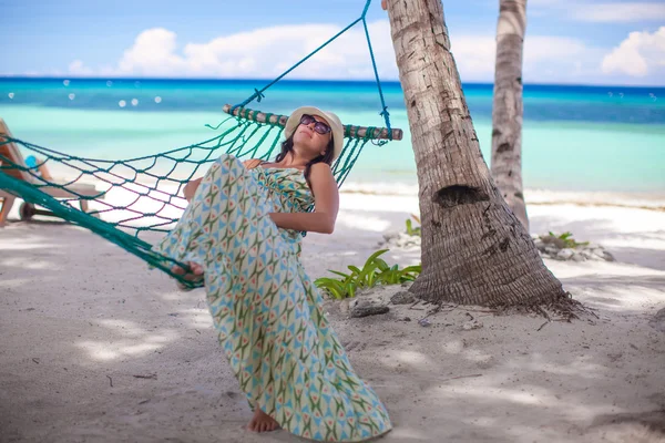 Ung kvinna ligga i hängmattan på tropical beach — Stockfoto