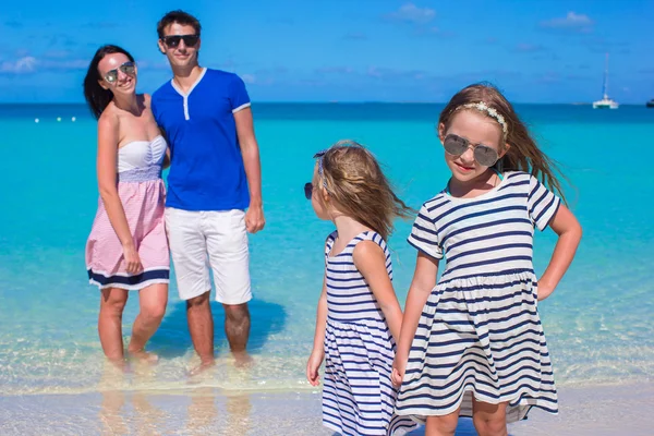 Молодая семья из четырех человек с двумя детьми на тропическом белом пляже — стоковое фото