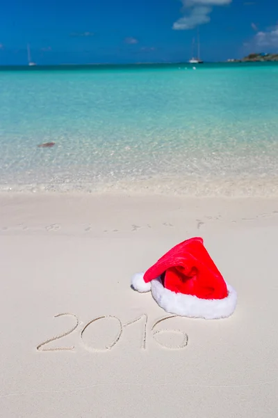 2016 geschreven op tropisch strand wit zand met xmas hoed — Stockfoto