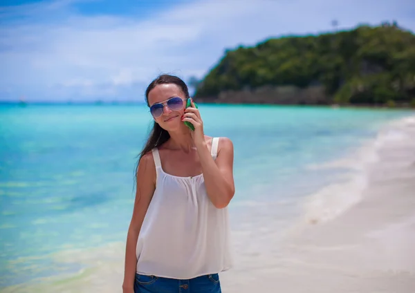 Klokke opp unge, vakre kvinne på stranden og snakke i telefonen – stockfoto