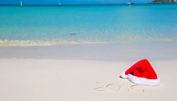 2016 escrito en la playa tropical de arena blanca con sombrero de Navidad — Foto de Stock