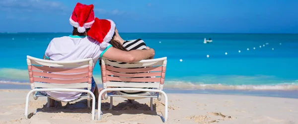 Jonge romantisch paar in Santa hoeden tijdens strandvakantie — Stockfoto