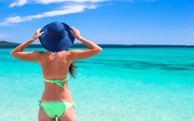 Genç güzel kadın rahatlatıcı beyaz kumlu tropikal plaj