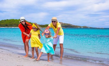 Happy family of four during beach vacation clipart