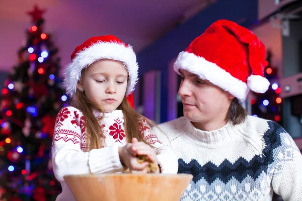 Papá joven con hija pequeña en Santa sombrero hornear galletas de jengibre —  Fotos de Stock