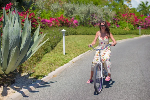 Молодая женщина на велосипеде на тропическом курорте — стоковое фото