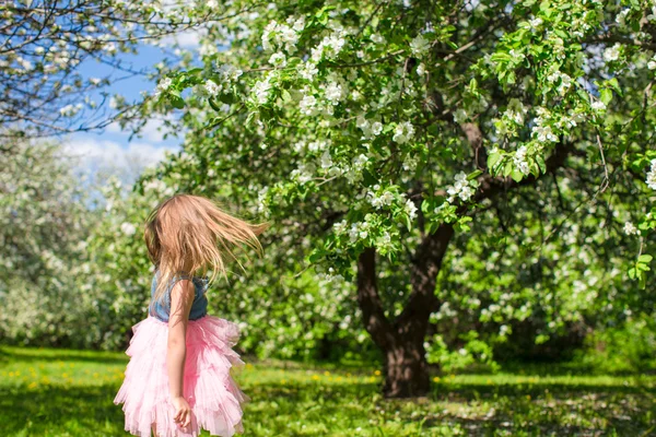 Entzückendes kleines Mädchen im blühenden Apfelgarten — Stockfoto