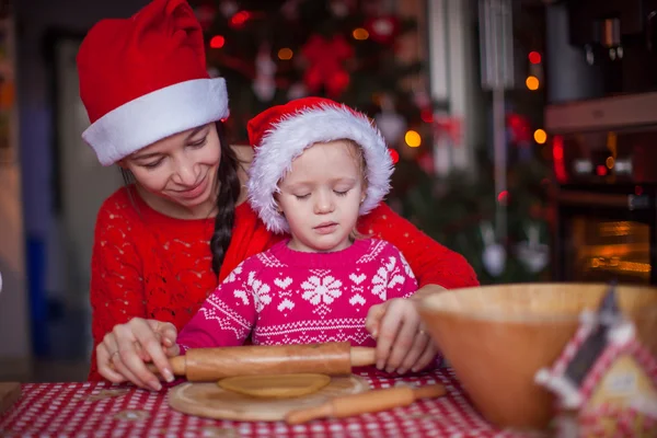 一緒にクリスマスのジンジャーブレッドのクッキーを焼く若い母親と小さな女の子 — ストック写真