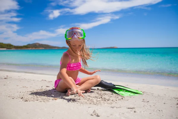 Little girl with flippers and goggles for ssnorkling on the beach — Stock Photo, Image