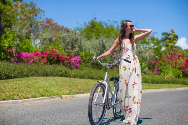 Young woman riding a bike on tropical resort — Stock Photo, Image