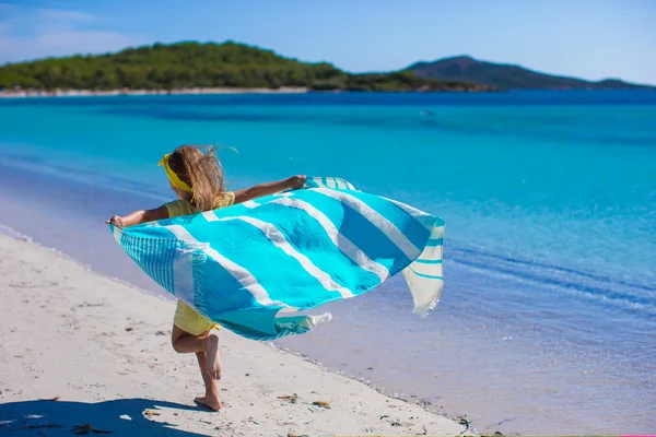 Pouco bonito menina se divertir com toalha de praia — Fotografia de Stock
