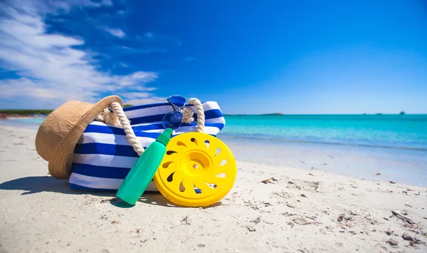 Stripe väska, stråhatt, solskydd och frisbee på tropiska stranden — Stockfoto