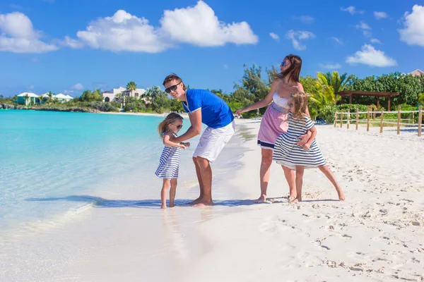 Familia feliz de cuatro durante las vacaciones en la playa —  Fotos de Stock