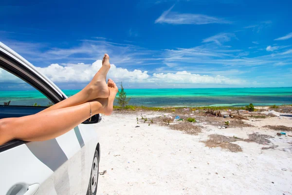 女性赤脚窗口的背景热带海滩上的一辆车 — 图库照片
