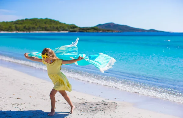 Küçük kız tropikal tatilde plaj havlusuyla eğleniyor. — Stok fotoğraf