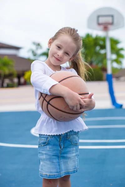 Petite fille avec basket sur le terrain à la station tropicale — Photo