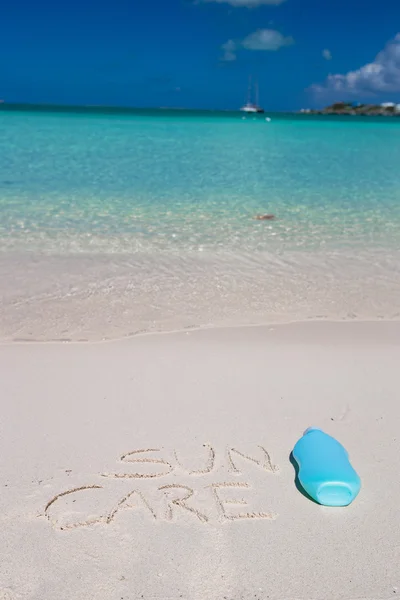 Suncare napsáno na tropické bílý písek a suncream — Stock fotografie