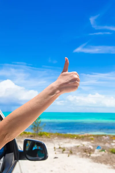 Kvinnlig hand visar tummen på stranden — Stockfoto