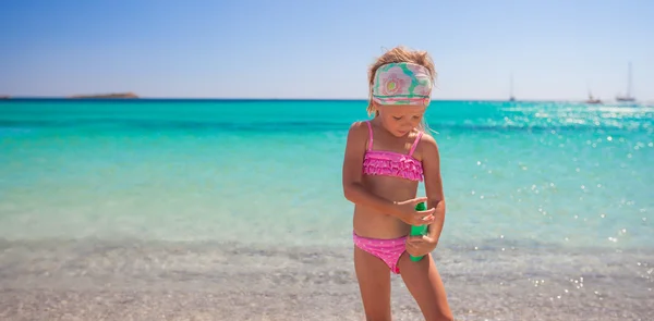 日焼けローション ボトルと水着で愛らしい少女 — ストック写真