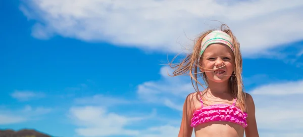 可爱的小女孩，在美丽的泳衣在地处热带的海滩玩得开心 — 图库照片