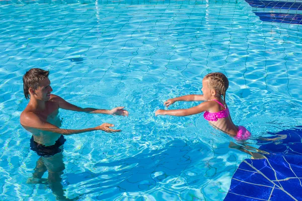 Pai e menina gostam de nadar na piscina — Fotografia de Stock