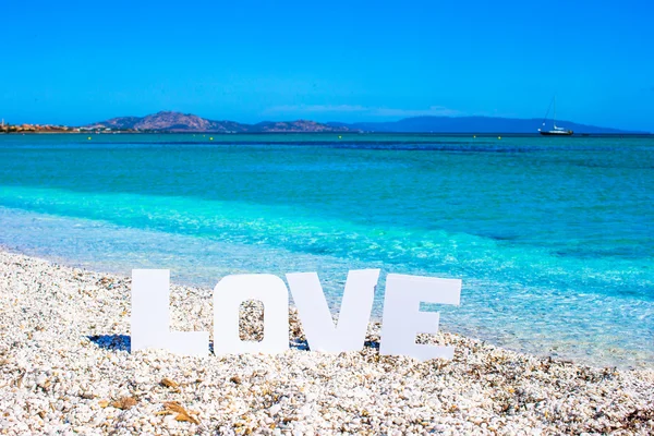 Word love on tropical beach background of turquoise sea and blue sky — Stock Photo, Image