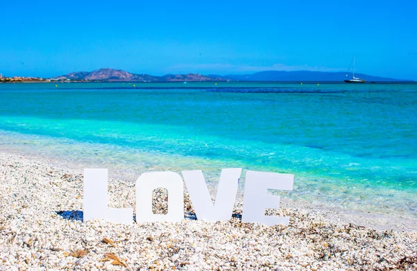 Word love on tropical beach background of turquoise sea and blue sky — Stock Photo, Image