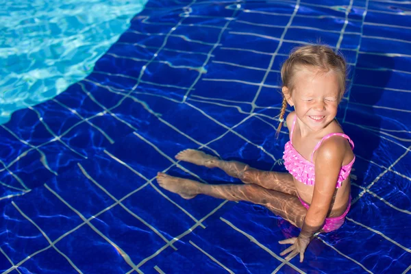 Αξιολάτρευτο χαρούμενο κοριτσάκι απολαμβάνει το κολύμπι στην πισίνα. — Φωτογραφία Αρχείου