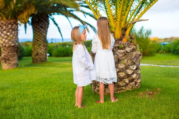 Adorable little girls in exotic resort at sunset — Stock Photo, Image