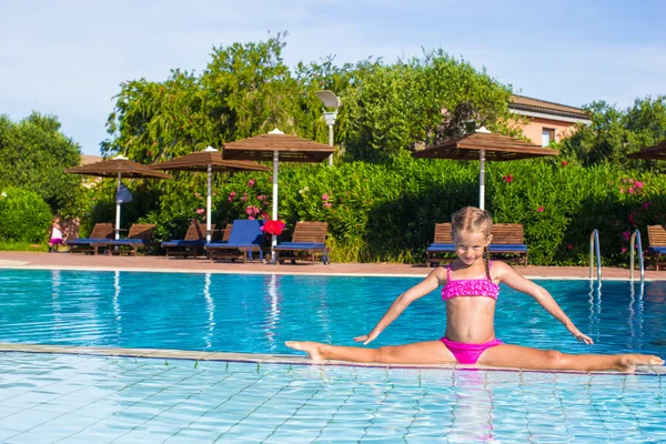 Bedårande liten flicka i poolen sitter på sträcktiderna — Stockfoto