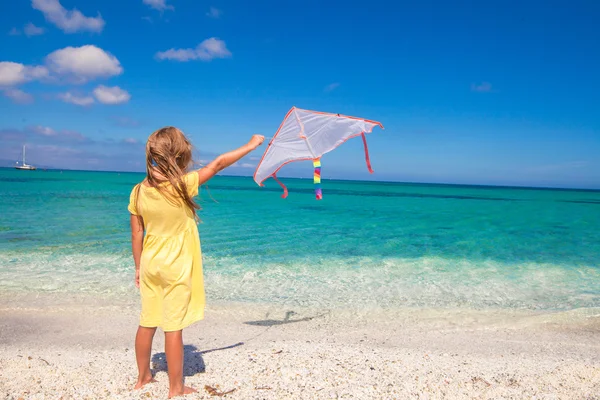 Niña linda jugando con cometa voladora en la playa tropical —  Fotos de Stock