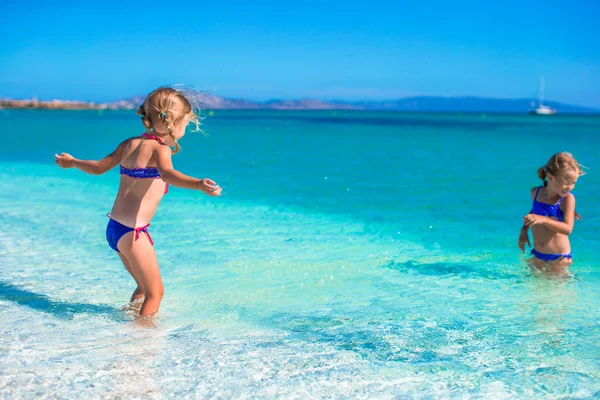 Urocze dziewczynki bawią się w płytkiej wodzie na tropikalnej plaży — Zdjęcie stockowe