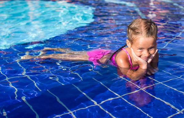 Schattig gelukkig klein meisje genieten van zwemmen in het zwembad — Stockfoto