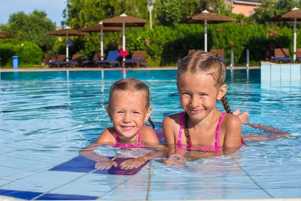Adorables niñas felices divirtiéndose en la piscina —  Fotos de Stock