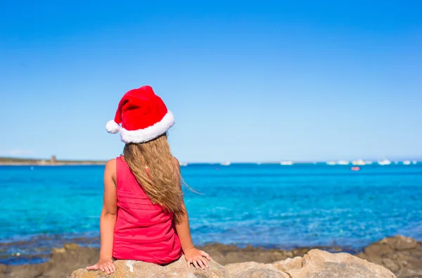 Roztomilá holčička v santa hat na pláži během dovolené — Stock fotografie