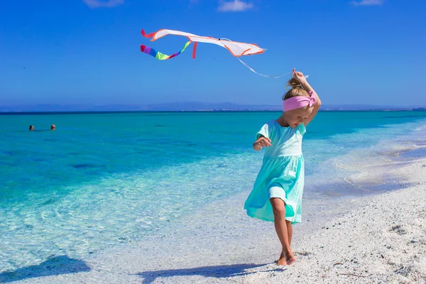 Mutlu kız tropik sahilde uçurtma uçan ile oynama — Stok fotoğraf