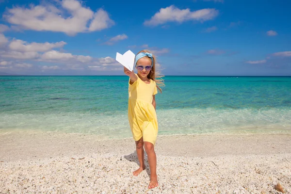 Niña feliz con avión de papel durante las vacaciones en la playa —  Fotos de Stock