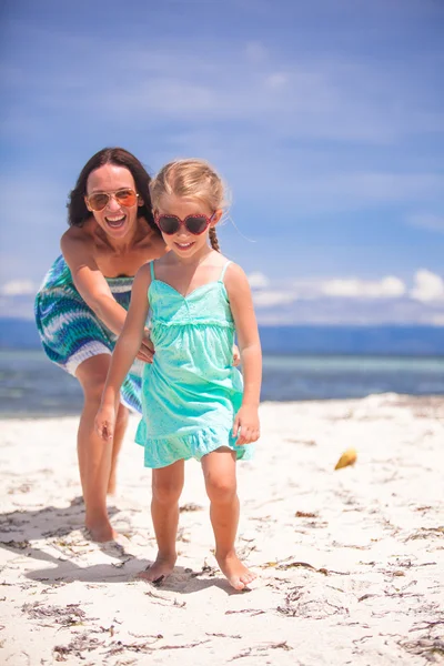 Lilla flickan och ung mamma att ha kul på tropical beach — Stockfoto