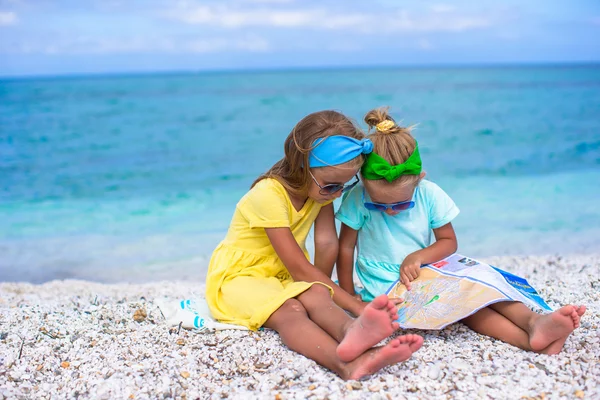 Malé roztomilé dívky s velkou mapou na tropické pláži dovolená — Stock fotografie