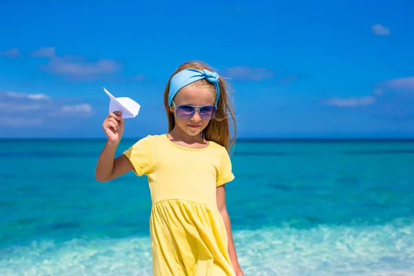 ビーチでの休暇中に紙飛行機との幸せな女の子 — ストック写真