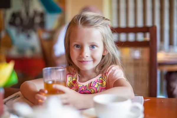 Adorable little girl having breakfast at resort restaurant outdoors — Stock Photo, Image