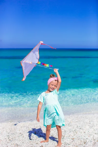 Malá šťastná dívka si hraje s létání draka na tropické pláži — Stock fotografie