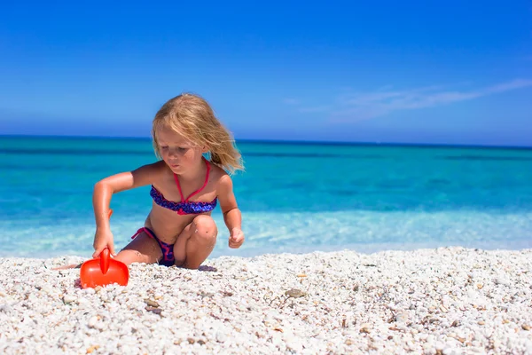 Pouco bonito menina divirta-se com brinquedos de praia na praia tropical — Fotografia de Stock
