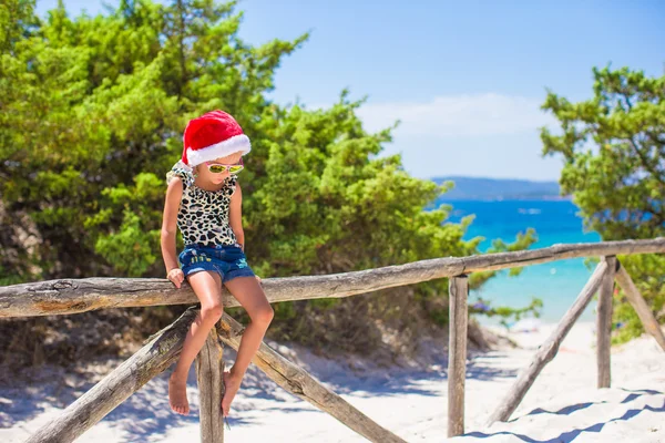 Roztomilá holčička v klobouku vánoční během dovolené na pláži — Stock fotografie