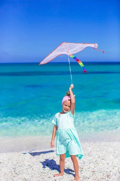 Gelukkig meisje spelen met vliegende kite op tropisch strand — Stockfoto