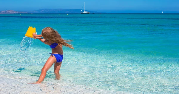 Adorable niña se divierten en aguas poco profundas en la playa tropical —  Fotos de Stock