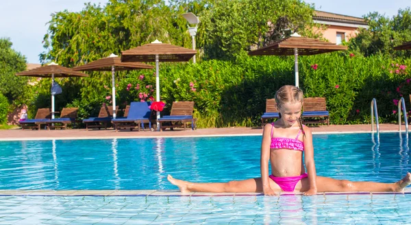 Adorabile bambina in piscina seduta sulle spaccature — Foto Stock