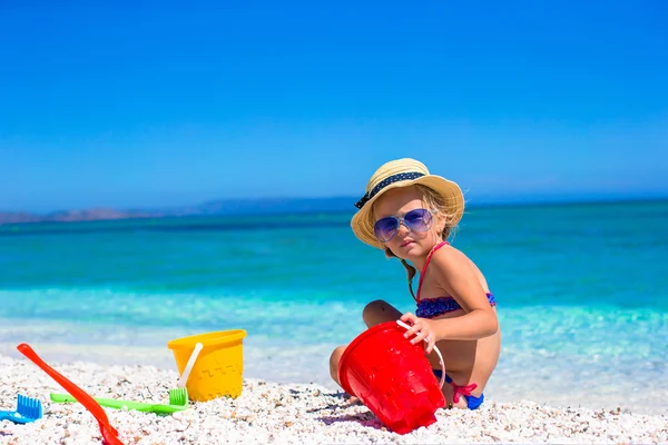 Niña linda jugando con juguetes de playa durante las vacaciones —  Fotos de Stock