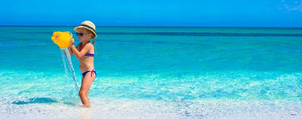 Schattig klein meisje spelen met speelgoed op strand vakantie — Stockfoto